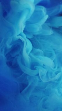 Dikey video. Dumanlı dalga. Mavi duman. Suluboya peçeler suya karışıyor. Odaklanamayan boya dokusuyla esrarengiz soyut arkaplan.