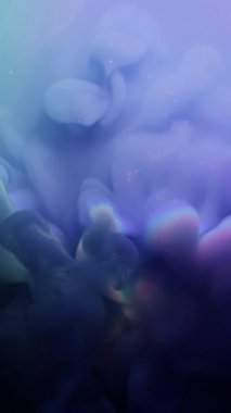 Dikey video. Duman patlaması. Işıldayan sıvıya yayılan mavi mor mürekkep sisi akışı fantezisi. Neon gökkuşağı ışığını ışınla soyut arkaplan .