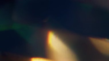 Parlak kiriş. Bulanık mercek titreşiyor. Odaklanmamış mavi yeşil renkli gökkuşağı dokusu soyut sanatın koyu siyah zemininde parıldıyor.