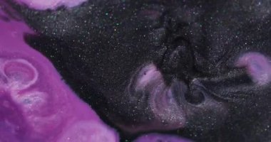 Işıl ışıl. Mürekkep sıvısı. Odaklanmamış pembe renk sıçrama parlatıcı dokusu soyut koyu siyah sanat arka planında yüzüyor..