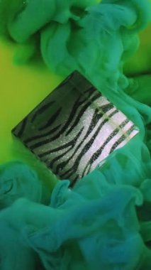 Dikey video. Boya damlası. Renkli duman bulutu. Odaklanmamış yeşil duman kübü sisi soyut desenli sanat arka planına mürekkep dokusu sıçratır.