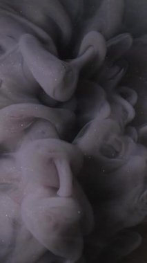 Dikey video. Renkli duman bulutu. Sis sıvısını boya. Odaklanamayan koyu siyah sis. Parıldayan mürekkep kokusu. Soyut altın sanat eserine sıçrıyor..