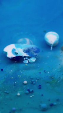 Dikey video. Sanat akışı. Kabarcık mürekkebi. Mistik bir şekilde çözünmüş mavi emülsiyon yüzen jel akrilik damlalar. Dalga karışık parçacıkları soyut arkaplan.