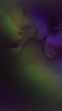 Dikey video. Suluboya kokusu. Sis sıvısı. Karamsar, ışıl ışıl bir sıvıda yayılan çok renkli mürekkep pigmenti. Soyut bulanık lens parıltılı su arkaplanı .