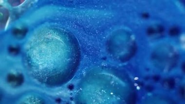 Parıldayan mürekkep. Sihirli mavi karışım. Renkli akış sıvısı parıldayan yağ boya dokusu soyut bulanık bokeh ışık sanat arka planında hareket ediyor.