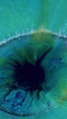 Dikey video. Parıltı patlaması. Boya dökülmüş. Sanat pigmenti ışıl ışıl ortası büyük mavi turkuaz akıntısı. Renkli akış soyut arkaplan.