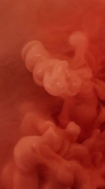 Dikey video. Dumanı karıştır. Mürekkep atışı. Portakal rengi bulut spreyi, su ve gaz akıntısı. Odaklanmamış renk dalgası sıvı soyut arkaplan dokusu.