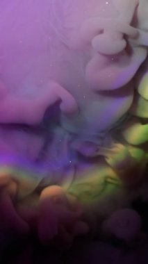 Dikey video. Mürekkep buharı. Sis karışımı. Mor sisli boya, ışıl ışıl parlayan sıvıda neon patlaması meydana getirdi. Mistik duman suyu soyut arkaplan .