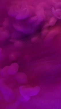 Dikey video. Boya patlaması. Parlayan toz. Pembe mor dalga akışı renk sıvısından ortaya çıkar. Gizemli su soyut arkaplan dokusu.