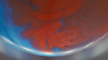 Akrilik yayılmış. Bulanık boya karışımı. Dairesel ışık lensinde kırmızı mavi emülsiyon karışımı. Odaklanamayan renk arkaplanı üzerindeki girdap akışı.