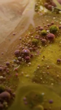 Dikey video. Sis sıvısı. Kabarcık mürekkebi. Altın parıldayan sarı mermer akıntısı şeffaf yağ bulanıklığı suyunda. Lüks sanat soyut arkaplanı.