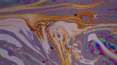 Yanardöner boya. Köpük sıvısı. Bulanık sarı mavi mürekkep akışı. Soyut, yuvarlak, ıslak arka planda pembe kırmızı lekeler..