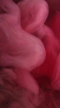 Dikey video. Dumanlı dalga. Sanat buharı. Yumuşak kırmızı suluboya peçeler suya karışıyor. Süzülen sisli boya dokusuyla esrarengiz soyut arkaplan.