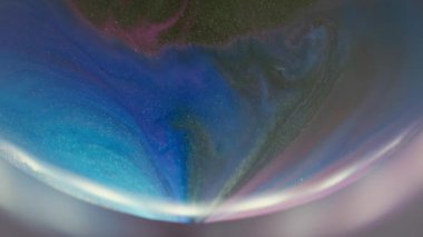 Mürekkep çözülüyor. Odaklanmamış boya dokusu. Mor soyut simler üzerine yayılan mavi siyah sıvı. Bulanık yuvarlak parlak lens renk çerçevesi.