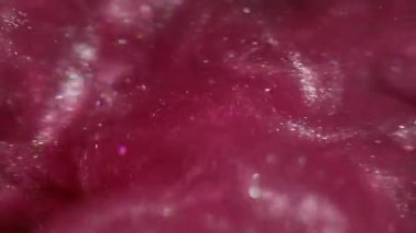 Köpüklü sıvı. Mürekkep bulanıklığı dalgası. Mor pembe kum metalik duman suyu harmanlıyor. Parlak akış sıçrama yayılan renk soyut siyah arkaplan.