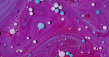 Mürekkep parçacıkları. Suyu boya. Odaklanmamış pembe renkli damlacıklar soyut sanat arka planında yüzen yağ beyaz mor sıvıyı parlatırlar..