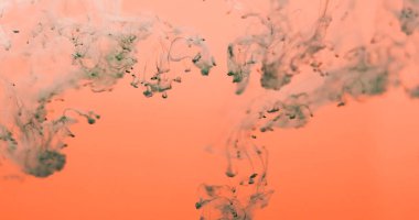 Mürekkep buharı. Duman karışımı. Turuncu suya gri dumanlı boya damlası. Sanatsal parlak renk soyut bulanık arka plan sızıntısı puslu.