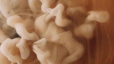 Duman bombası. Buhar bulutu. Soyut koyu siyah arkaplan üzerine yayılan su patlaması akışında çözünmüş turuncu renkli sıçrama mürekkebi.