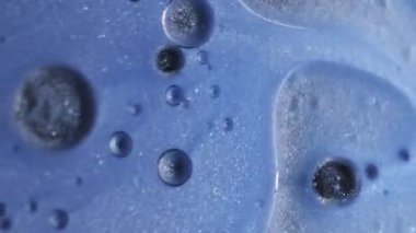 Işıl ışıl. Yağ sıvısı dokusu. Soyut sanat akrilik zemin üzerinde yüzen su yuvarlak parlak mürekkep damlasına odaklanmış mavi renk boyası.