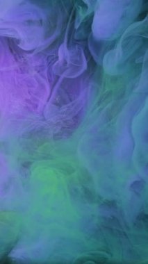 Dikey video. Duman bulutu. Su büyüsü. Odaklanmamış mor renkli sisli boya mürekkep deseni soyut ışıldayan sanat arka planında ışıldayan bulutsu buharı..