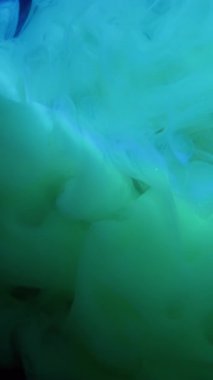 Dikey video. Duman dalgası. Puf boyası. Koyu suda yeşil mavi girdap bulutu akıyor. Gizemli odaksız peçe sanatı soyut neon akım siyah arkaplan .