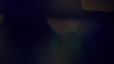 Göz kamaştırıcı etki. Bulanık yansıma. Odaklanamayan sarı yeşil renk dokusu soyut sanatın koyu siyah arka planında yanıp sönüyor..