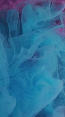 Dikey video. Sis girdabı. Mürekkep su sıçratır. Odaklanmamış mavi renk parlayan boya dokusu soyut pembe sanat eserlerinde ışıl ışıl parlayan buhar açık arkaplan.