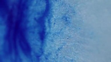 Parıldayan boya. Odaklanmamış sim sanatı. Yanıp sönen mavi renkli sıvı akışı bulanık bokeh hafif modern arkaplanda hareket ediyor.