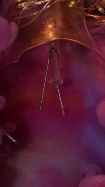 Dikey video. Parıldayan bulut. Sanat sıvısı. Çok renkli, köpüren, köpüren, su emülsiyonu kırık cam ampulü. Parlak pembe boya yüzeyi soyut arkaplan.