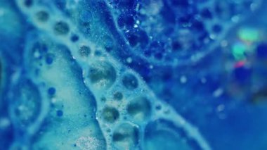 Parlayan sıvı. Odaklanamayan parlak parıltı. Yağ dokusu yaratıcı mavi renk mürekkebi soyut bulanık bokeh ışık arkaplanı üzerinde sıvı akışını sağlar.