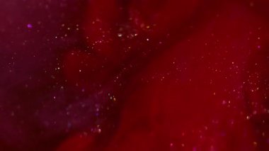 Parıldayan duman. Parıltılı bir karışım. Parlak toz parçacıkları harmanlayan parlak kırmızı mor kıvılcımlar. Boya akışı soyut bulanık arkaplan.