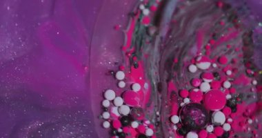 Akrilik boya. Akış karışımı. Odaklanmamış pembe beyaz yağ pigmenti su kabarcıkları soyut arkaplanda dönen ıslak damlalar.