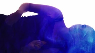 Dikey video. Parti silueti. Gece hayatı tarzı. Çifte pozlama, parlak mavi ışık, zarif bir kadının beyaz üzerinde dans etmekten zevk alışının ana hatları..
