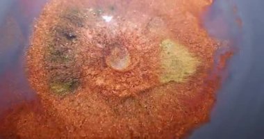 Parıltı sıçraması. Sıvı dökülmesi. Bulanık altın sarısı mürekkep rengi parlak baloncuklar soyut koyu mavi arkaplan üzerinde yüzen sıvı..