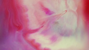 Canlı boya akışı. Odaklanmamış boya dokusu. Mor soyut ışıltı arkaplanına yayılan kırmızı beyaz sıvı damlası. Bulanık parıltılı sanat rengi akrilik.