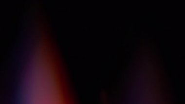 Şafak. Bulanık lazer. Soyut sanatın koyu siyah zeminine odaklanmış mavi yeşil çok renkli gökkuşağı spektrum ışığı.