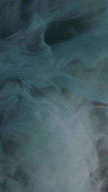 Dikey video. Grunge sisi. Duman sürükleniyor. Kara bulutlar parıldayan yüzeye yayılır. Suyun soyut arka planında karmaşık buklelerle kaplanmış gri boya..