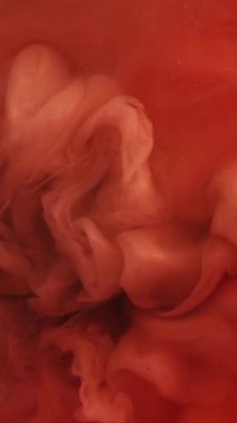 Dikey video. Parlak duman. Boyayla boyanmış. Suluboya damlası mürekkep karışımını renk suyuna döker. Kırmızı turuncu sanat eseri nem dokusu soyut arkaplan bulanıklığı.