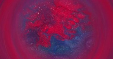 Odaklanmamış parlak boya. Akrilik sıvı karışımı. Bulanık kırmızı mor renkli parlak akış soyut sanat arka planında daireler çiziyor..