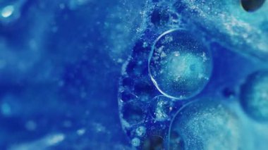 Jel köpükleri. Odaklanmamış sim rengi. Mavi yanıp sönen parlak boya sıvısı soyut bulanık bokeh ışığı modern arka planda hareket ediyor.