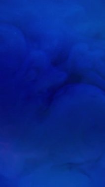 Dikey video. Sanat sıvısı. Duman boyası. Soyut arka planda mavi patlama sıvısı kaynayan mürekkep akışı. Su neon rengi odaklanmış daire lensi .