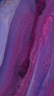 Dikey video. Mermer akışı. Parlak mürekkep. Odaklanmamış pembe mor renk parlak toz cilası sıvı pigment karışımı soyut arkaplan.