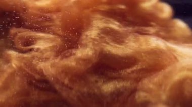 Parlayan mürekkep. Toz bulutu sıvısı. Altın parçacıklar suya parlak pigmentler saçar. Parlak soyut bulut patlaması siyah arkaplan.