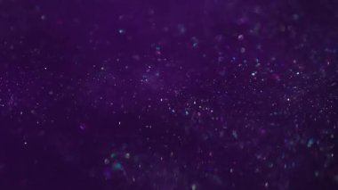 Parıltı dalgası. Odaklanamayan akış. Mor renkli mürekkep parlak sanat suyu akışını kaplıyor. Bulanık desen parlayan parçacıklar soyut arkaplanı harmanlıyor.