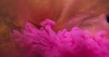 Dönen sıvı. Arkaplanı boya. Odaklanmamış pembe turuncu altın rengi duman parlatıcısı yaratıcı soyutlamaya yayılıyor..