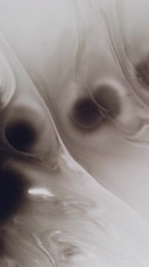 Dikey video. Boya damlası. Kara damla. Koyu su lekesi boyasıyla karıştırılmış sanat sıvısı dalgası. Beyaz yüzey grunge kirliliği dağınık yayılan soyut arka plan.