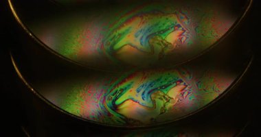 Benzin sıvısı bulanıklığı. Yüzen mürekkep. Siyah arka planda çift renkli sıvı kemer yağı girdabı. Çember lens soyut gradyan parıltısı.