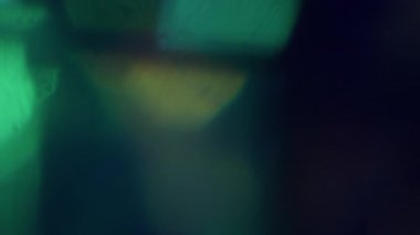 Parlak kiriş. Bulanık ışın soyut. Odaklanmamış yeşil mavi, çok renkli, yanıp sönen ışık, sihirli mercek dokusu koyu siyah arkaplanda..