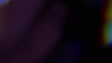 Işıl ışıl. Bulanık ışık. Odaklanmamış mavi yeşil renkli ışık spektrumu soyut koyu siyah arkaplanda hareket ediyor.