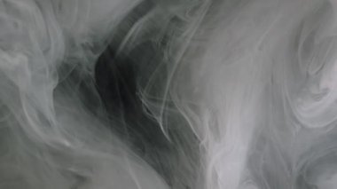 Duman bombası. Buhar bulutu. Odaklanmamış mor renkli sisli doku su patlaması akışında mürekkep sıçratır soyut sanat kara arka planda yüzer.